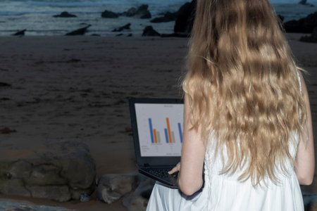 Working remotely on the laptop in beach. Working remotely on the laptop computer through the internet. Working travellingの写真素材