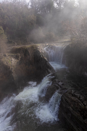 A mesmerizing display of nature: The magnificent Delika Waterfall amidst the misty mountains of Vizcayaの写真素材