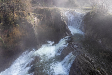 A journey through the enchanting Basque countryside: Discovering the beauty of Delika Waterfall amidst the fog and lush greeneryの写真素材