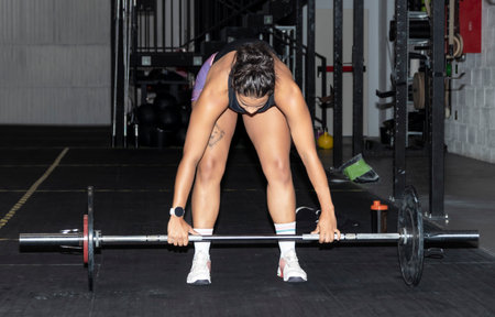 latin woman lifting weights in a gymの写真素材