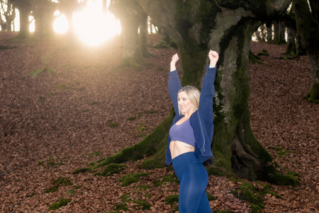 Sexy women are lifting their hands in a cheerful manner in natureの写真素材