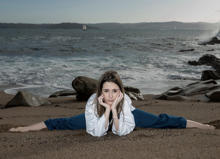 pretty flexible blonde woman doing stretching on the beachの写真素材