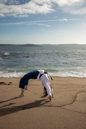 woman cartwheeling in kimono on the beachの写真素材