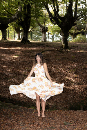 Magical Autumnal Serenade: A Beautiful Woman in Greenery and Delightful Smilesの写真素材