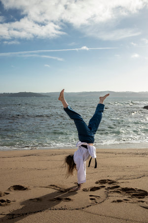 woman cartwheeling in kimono on the beachの写真素材