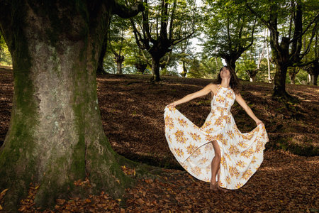 Tranquil Nature Bliss: A Serene Woman in a Long Dress Amongst Lush Woodsの写真素材
