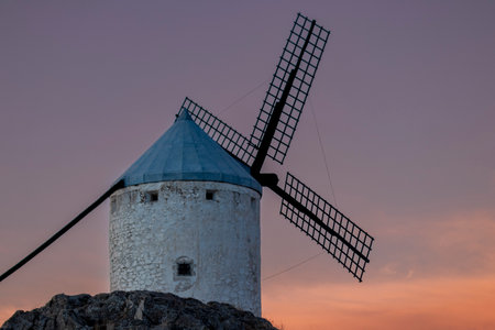 Captivating Sunset Views: Exploring the Enchanting Windmills of Consuegra in Toledoの写真素材