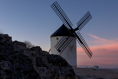 Tranquil Charm of Consuegra: Witnessing the Timeless Beauty of Windmills at Sunset in Toledoの写真素材
