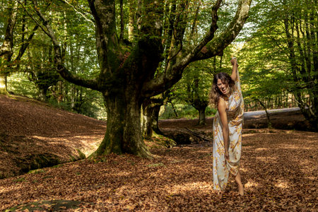 Enchanted Forest Escapade: Radiant Young Woman Reveling in the Vibrant Colors of Autumnの写真素材