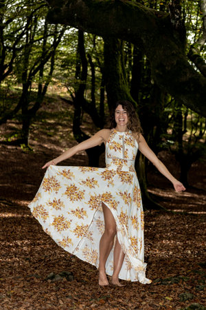 Autumn Delight: Playful Brunette Embracing the Joy of Nature in a Long Summer Dressの写真素材