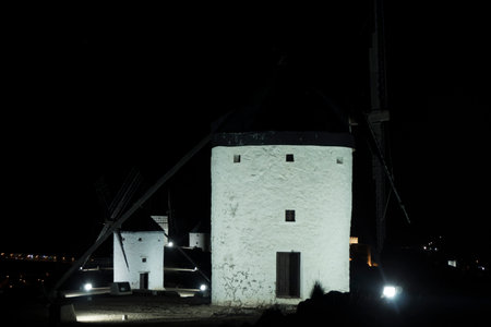 Historic Charm: Windmills in Consuegra Aglow with Nighttime Splendorの写真素材