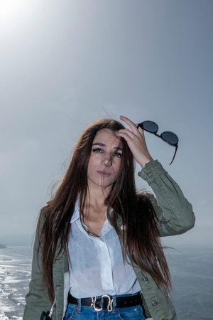 Effortless Sophistication with Long Hair and Sunglasses Gracing Her Handの写真素材