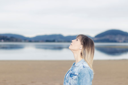 Capturing the Tranquil Moment of a Gorgeous Woman by the Seashoreの写真素材