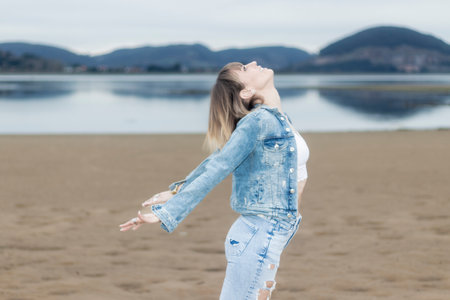 Coastal Mindfulness: Gorgeous Woman Embracing Peace and Deep Breath by the Ocean in Winterの写真素材