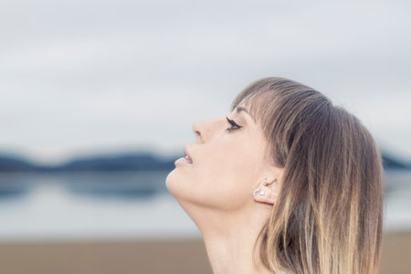 Ethereal Beauty: Graceful Woman's Dreamy Gaze into the Infinite Horizon Captures the Essence of Hopeの写真素材