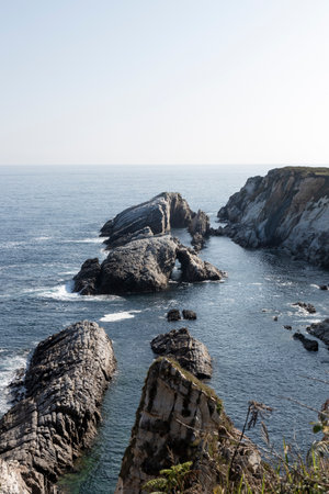 Scene of Jagged Rocks and Ocean under a Light Blue Skyの素材