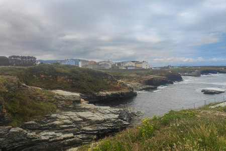 Coastal Town s Charm: Overlooking the Rocky Shoreline and Orange-Roofed Buildingsの写真素材