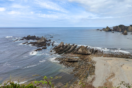 rocky coastline with a sandy beach, blue ocean, and scattered islands, taken from a high vantage pointの写真素材