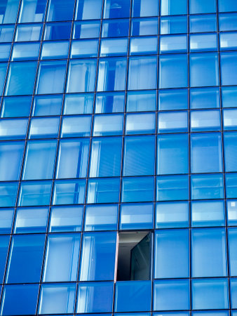 glazed facade of a skyscraper with a single open window