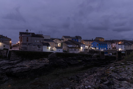 tranquil coastal town under the enigmatic embrace of dusk, where artificial lights and natural...
