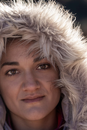 Close-up Portrait of Woman in Winter Fur Hood with a Warm, Intense Gaze