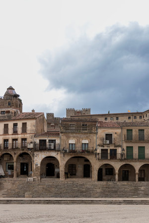 The historic plaza mayor in aÃ­nsa, spain, showcases medieval architecture with a dramatic cloudy sky overheadの写真素材