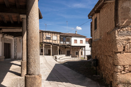 CalataÃ±azor's main square showcases traditional architecture, stone columns, and cobblestone streets under a clear blue skyの写真素材
