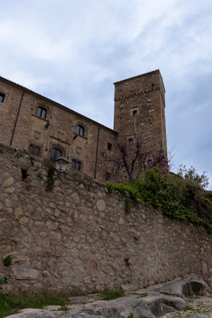 Stone tower rising above castle walls in a cloudy sky, showcasing medieval architectureの写真素材