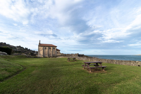 Picnic area with tables in front of the hermitage of san telmo, a historical building facing the sea in zumaiaの写真素材