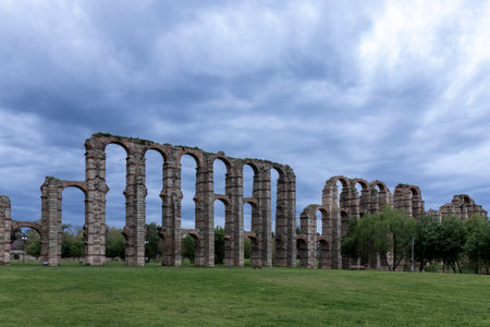 The impressive los milagros aqueduct stands tall against a cloudy sky, showcasing roman engineeringの写真素材