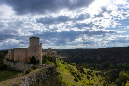 Impressive ruins of the medieval castronuÃ±o castle standing on a hill overlooking a valley in valladolid, spain, under a dramatic skyの写真素材