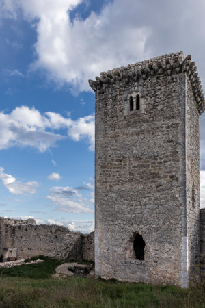Majestic stone tower rising against a cloudy blue sky in the rocca calascio ruins, a historic landmark in abruzzo, italyの写真素材