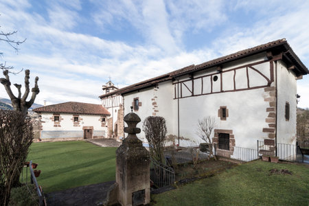 Traditional basque church showcasing half-timbered architecture, nestled in a serene landscape with a well-maintained lawnの写真素材