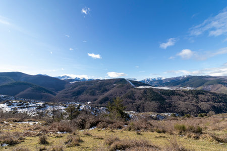 Snow-capped pyrenees mountains with green vegetation under a clear blue sky in winterの写真素材