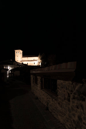 Nighttime view of a lit church in a serene village settingの写真素材