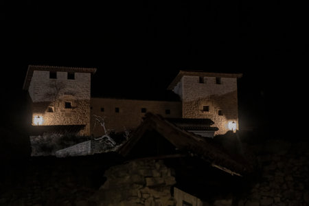 Stone fortress at night with warm glowing lightsの写真素材