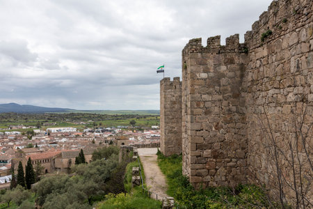 Extremadura flag waving on the battlements of the jerez de los caballeros medieval castle overlooking the town and surrounding landscapeの写真素材