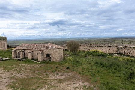 Ruins of montemor-o-novo castle overlooking the vast plains of alentejo, portugal, under a cloudy skyの写真素材