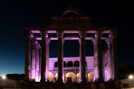 The roman temple illuminated with purple lights at night