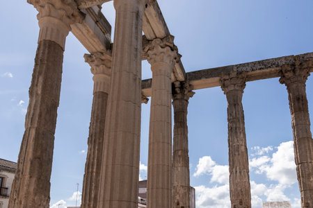 Fluted columns and architrave of the temple of diana in mÃ©rida, spain, reaching towards a blue...