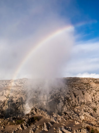 Rainbow forming over the rocky coast and bufones de pria, a unique geological formation in asturias, spainの写真素材