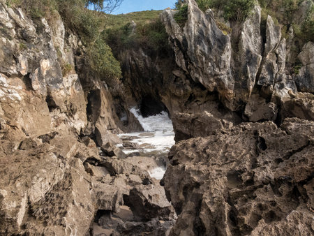 Powerful ocean waves crashing against rocks and cliffs on the coast of asturias, spain, creating a dramatic seascapeの写真素材