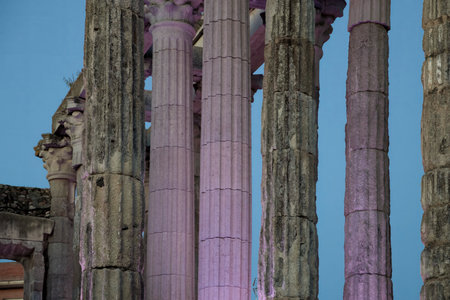 Majestic columns of the roman temple of diana illuminated in soft purple light at dusk in merida,...
