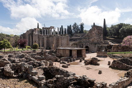 Experiencing ancient roman theatre ruins and artifacts under a cloudy sky in merida, spain