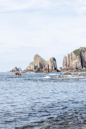 Ocean waves crashing on the rocky coast and towering sea cliffs of asturias, spainの写真素材