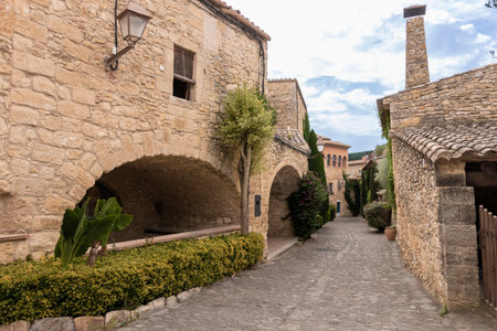 Cobblestone alley winding through ancient stone buildings in peratalladaの写真素材
