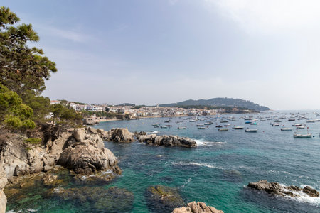 Calella de palafrugell village with boats anchored in turquoise water along the costa brava coastlineの写真素材