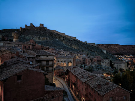 AlbarracÃ­n, spain, showing the historic village and fortress walls built on a hillside at dusk