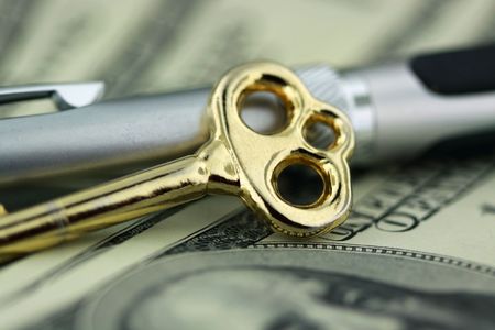 one hundred dollar bill closeup with a gold key and pen - finance conceptの写真素材