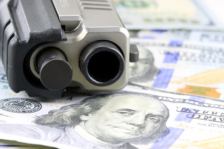 Hand Gun with American Currency - Hundred Dollar Bill Financial Security concept